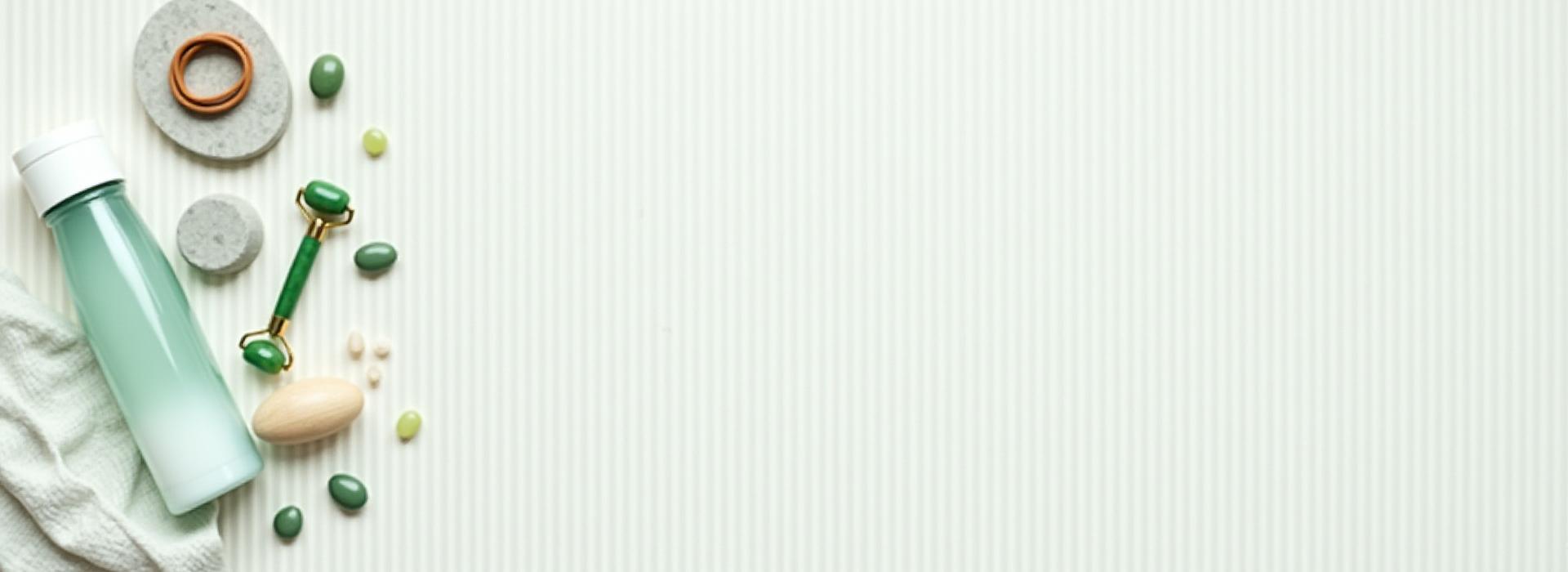 A serene flat lay of various high-quality, aesthetic wellness products like supplements bottles, a jade roller, and resistance bands on a light textured background.